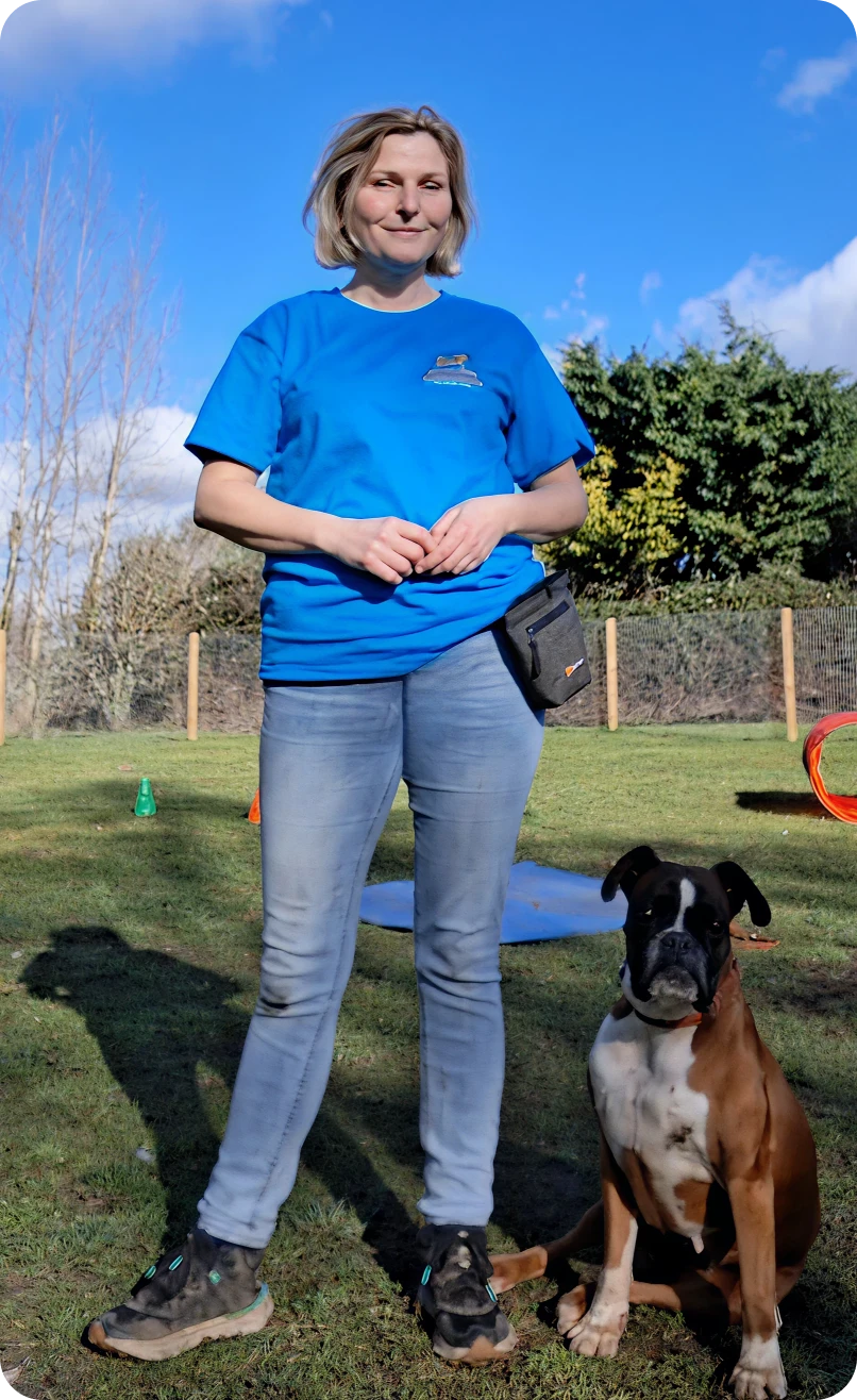 Smiling woman beside sitting boxer dog